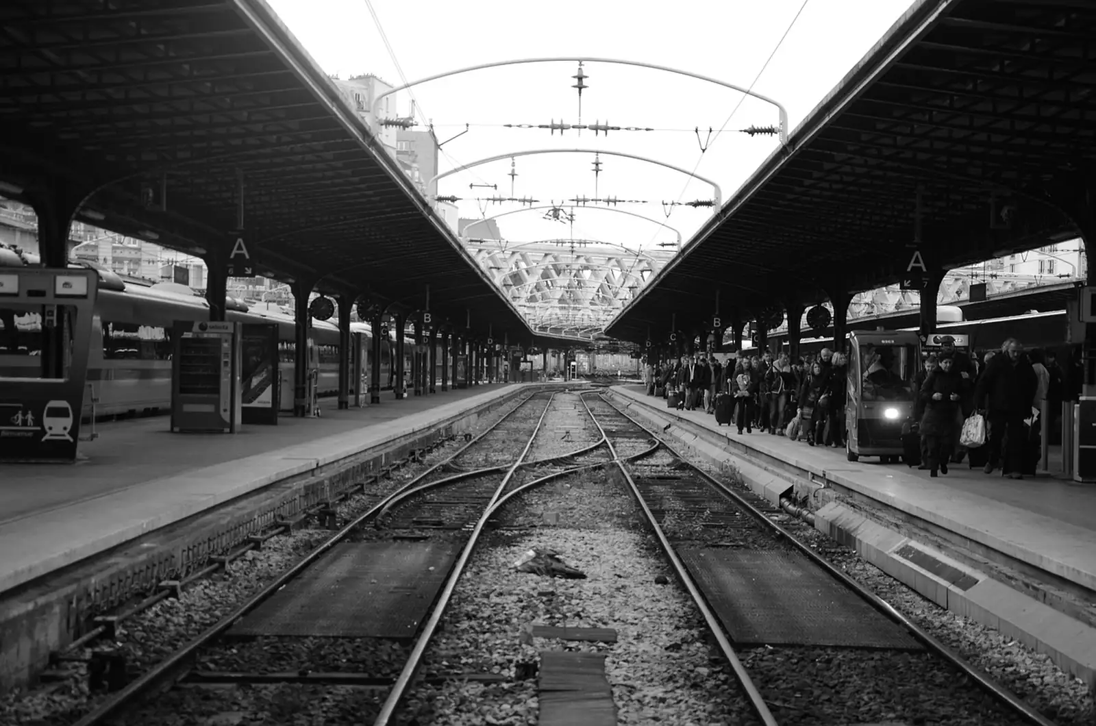 Voies et quais de la gare de l'Est à Paris, voyageurs alignés le long du quai