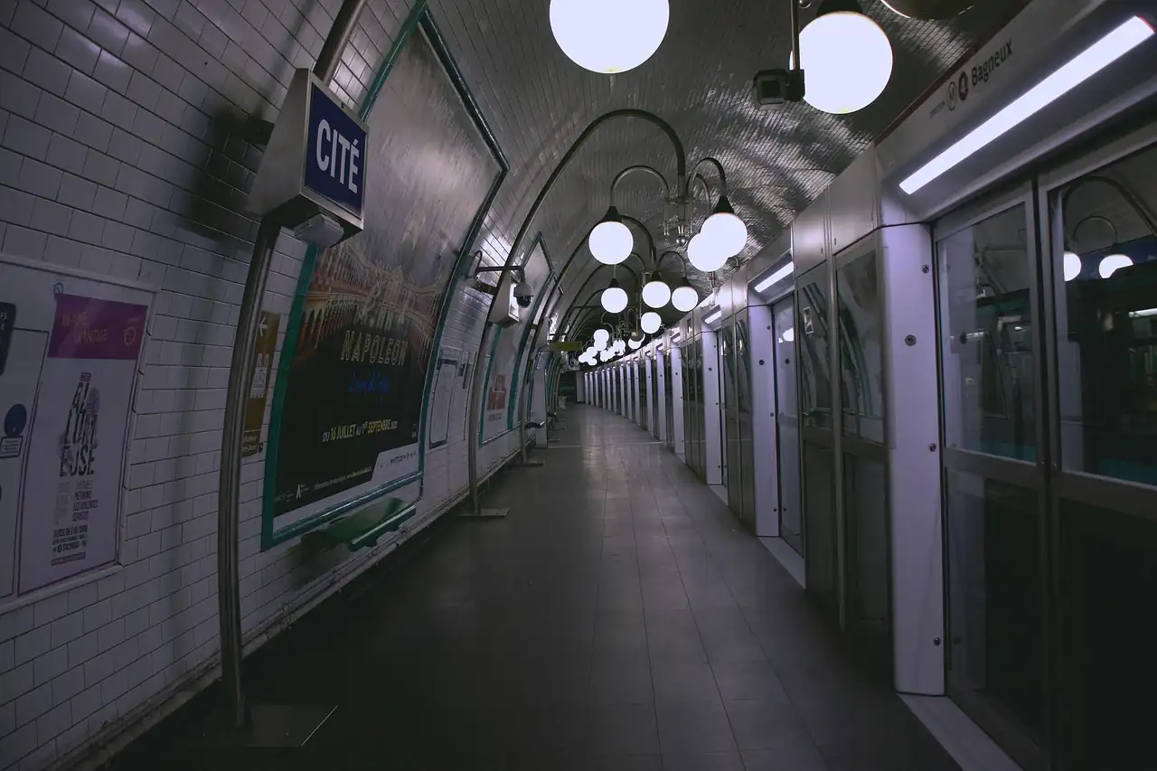 Quai vide de la station Cité, portes palières, globes lumineux et carrelage blanc en voûte