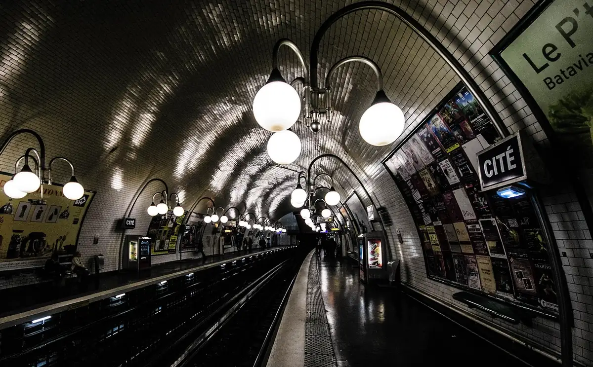 Quai de la station de métro Cité, voûte carrelée et lampadaires à globes blancs, panneau Cité à droite