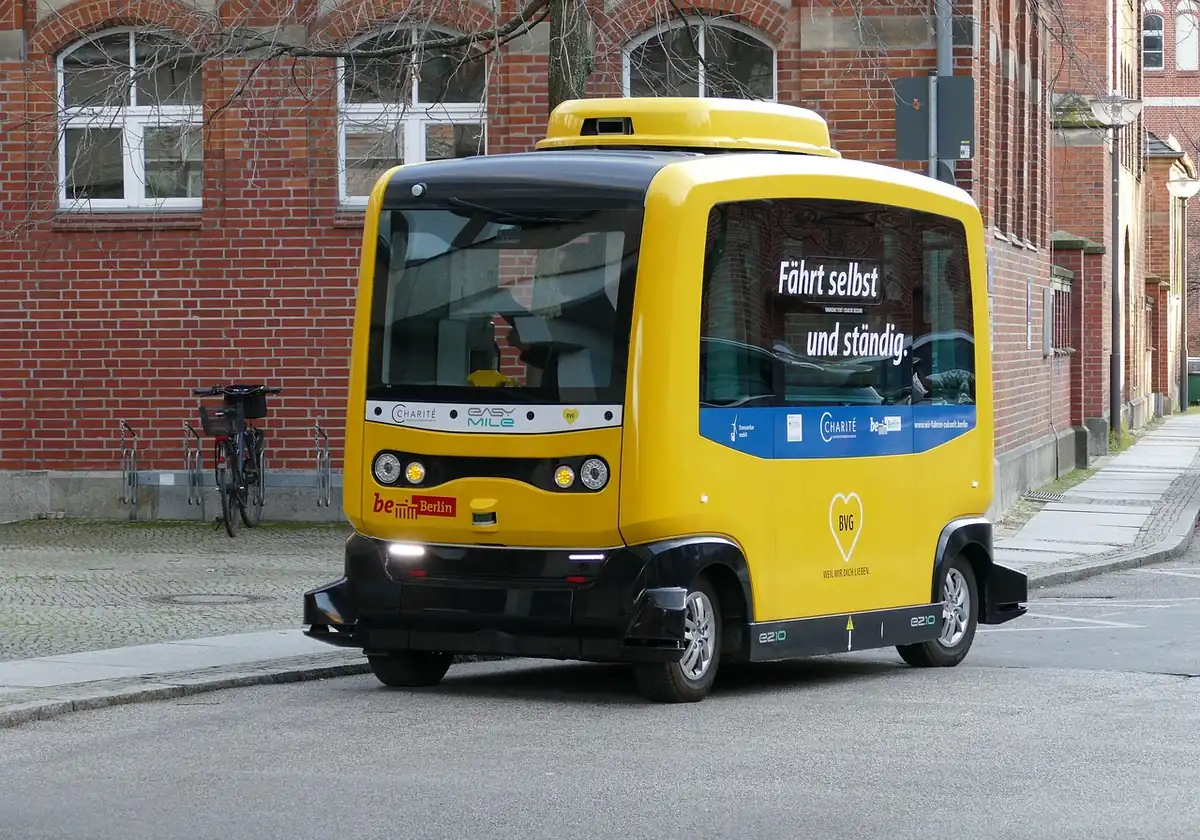 Navette autonome jaune EasyMile de la BVG garée devant un bâtiment en briques rouges à Berlin