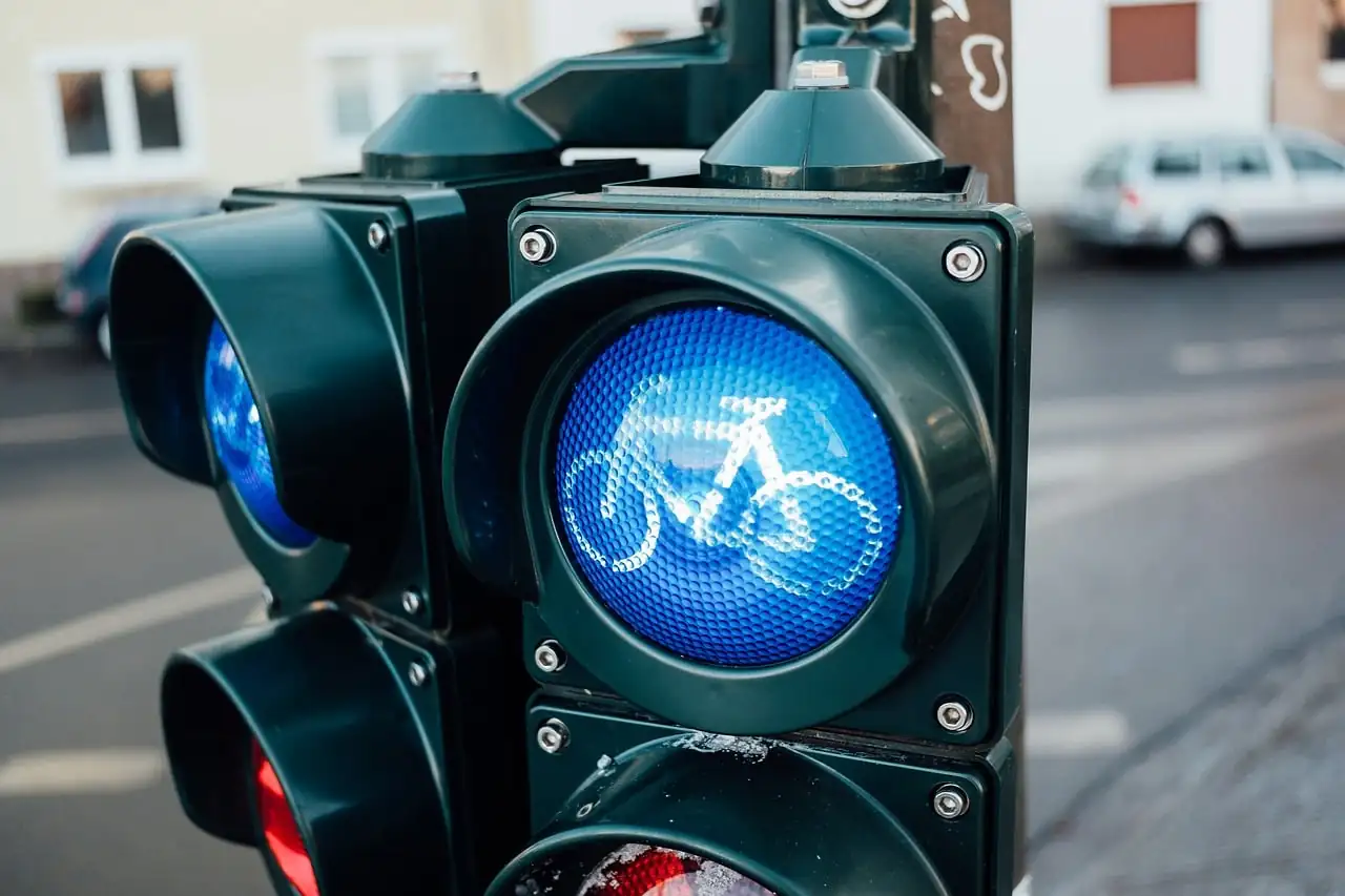 Feu de signalisation réservé aux vélos, pictogramme bleu allumé, à un carrefour en ville